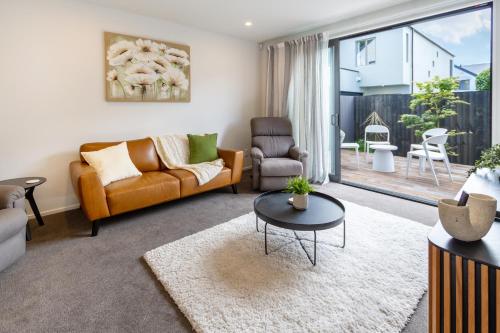 a living room with a couch and a table at Charming 3-Bedroom Escape Carpark in Christchurch