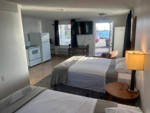a hotel room with two beds and a kitchen at Thames Inn and Marina in Groton