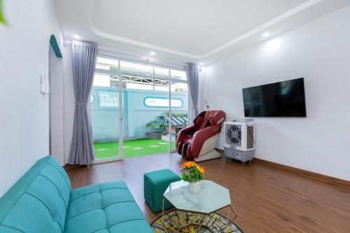 a living room with a blue couch and a tv at Villa VTS - Gần Biển Thùy Vân - Free Karaoke in Vung Tau
