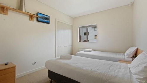 Un dormitorio con dos camas y una ventana. en Chalet Hotham 01, en Monte Hotham