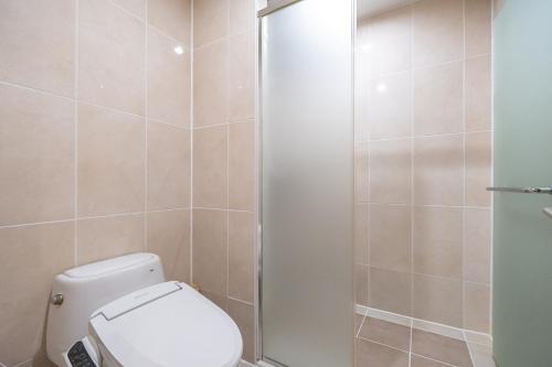 a bathroom with a toilet and a shower at Elysian Gangchon Resort in Chuncheon
