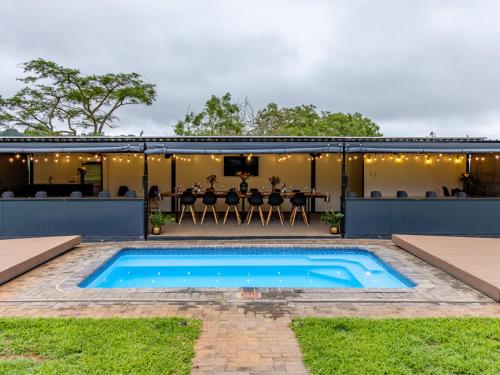 a swimming pool in the backyard of a house with a table at Da Loose Mongoose in White River