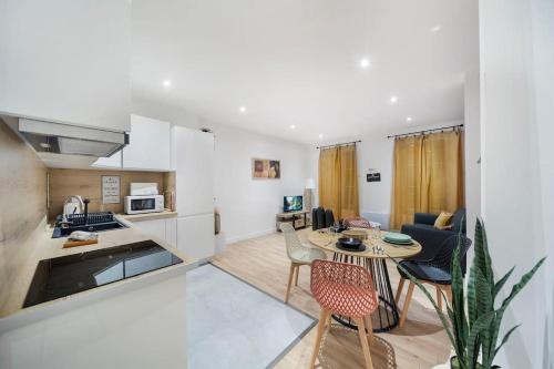 une cuisine et un salon avec une table et des chaises dans l'établissement L'escapade Terra Cotta, à Chalon-sur-Saône