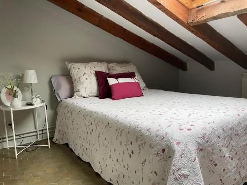 a bedroom with a bed with pink pillows at La Buhardilla in Valladolid
