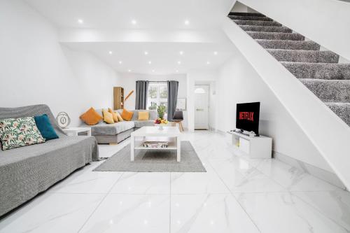a white living room with a couch and a table at Albert Street Retreat, Windsor in Windsor