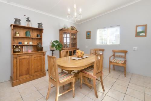 a dining room with a wooden table and chairs at Hugo Haven in Bredasdorp