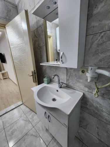 Un baño con un lavabo blanco y un espejo. en esa apartman 1, en Trabzon