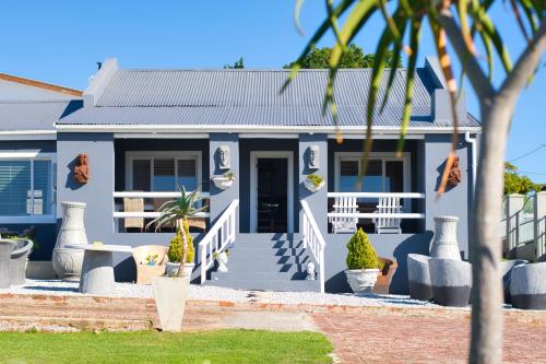 a blue house with stairs and plants in front of it at Hugo Haven in Bredasdorp