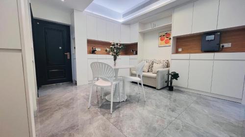 a room with a table and chairs and a couch at House of Great White Apartment in Shenzhen