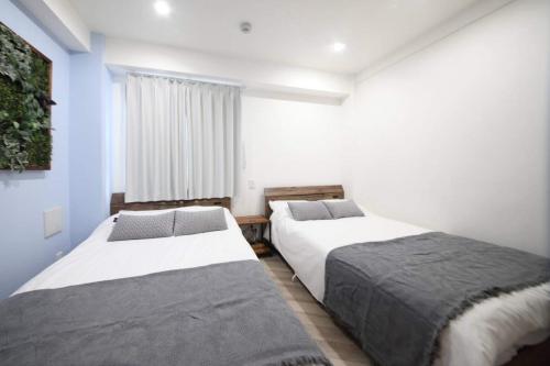 een slaapkamer met twee bedden en een raam bij Shibuya WAVE 302 in Tokyo