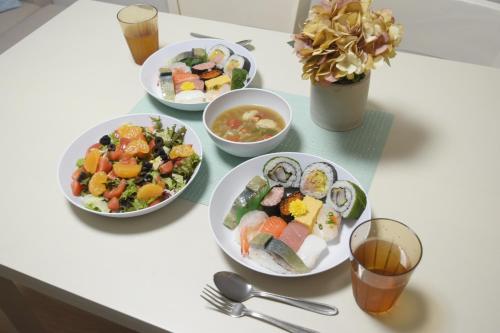 a table with four plates of food on it at Rooftop Haven 新小岩 in Tokyo