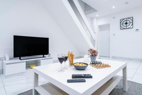 a white living room with a white table and a tv at Albert Street Retreat, Windsor in Windsor