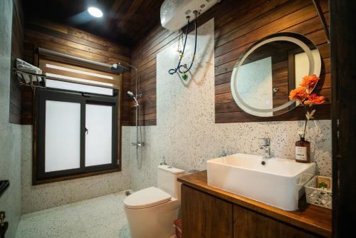 a bathroom with a sink and a toilet and a mirror at Mimi's House Sóc Sơn - Venuestay in Ấp Ðông Ðô