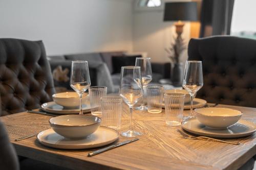 una mesa de madera con platos y vasos. en Tofthof een, en Westerhever