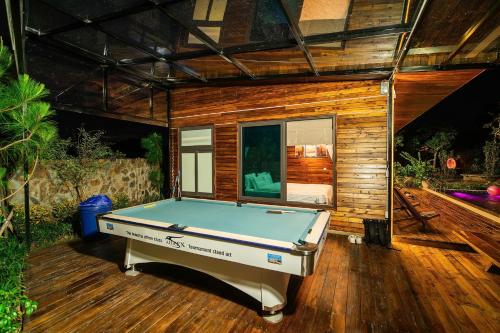 a pool table in front of a tiny house at Mimi's House Sóc Sơn - Venuestay in Ấp Ðông Ðô