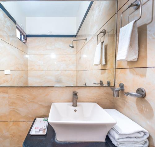 a bathroom with a white sink and a mirror at Hotel Royal Palace in Sāgar