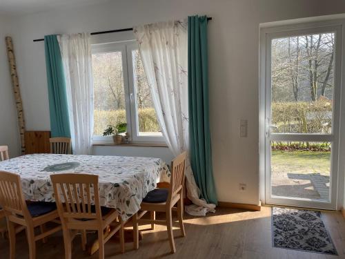 a dining room with a table and chairs and a window at Bigge Elements Gästezimmer 5 "Himmel" 2 Personen in Olpe
