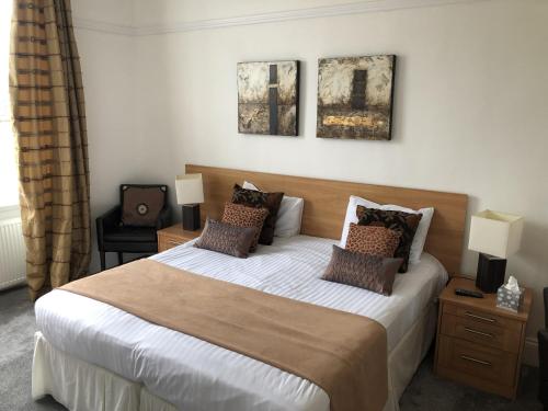 a bedroom with a large bed with three pictures on the wall at Deeping Stage in Market Deeping