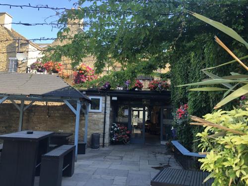 a patio with benches and flowers on a building at Deeping Stage in Market Deeping
