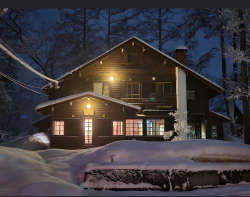 a house lit up in the snow at night at 白馬蔵雲Zone in Hakuba