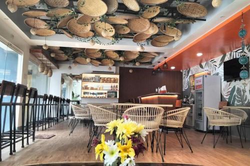 a restaurant with chairs and tables and a ceiling with hats at Wanderlust Bed and Breakfast Puerto Princesa in Puerto Princesa City