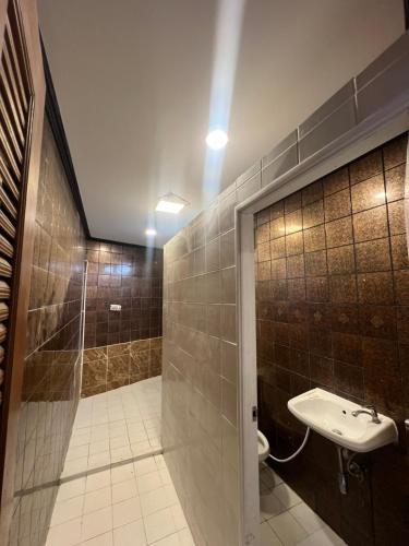 a bathroom with a sink and a shower and a toilet at Maland House Hostel - Pattaya soi 14 Saisong Road in Pattaya South