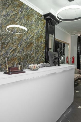 a lobby with a white counter with a laptop on it at The Rest Hostel in Astana