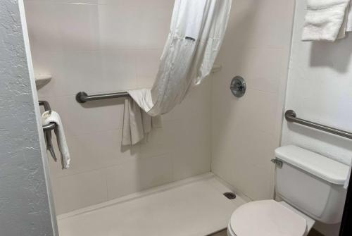 a small bathroom with a toilet and a shower at Days Inn by Wyndham El Reno in El Reno