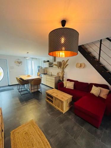 a living room with a red couch and a table at Appartement en petite Camargue in Saint-Laurent-dʼAigouze