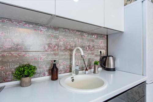 a bathroom with a sink and a pink tiled wall at Ушсункар Nice in Almaty