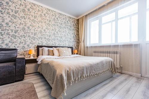 a bedroom with a bed and a window at Ушсункар Nice in Almaty