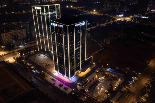 a tall building with lights on it at night at Courtyard by Marriott Nanning Wuxiang in Nanning