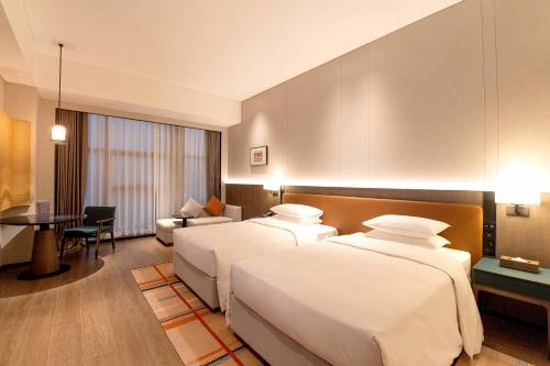 a hotel room with two beds and a table at Courtyard by Marriott Nanning Wuxiang in Nanning