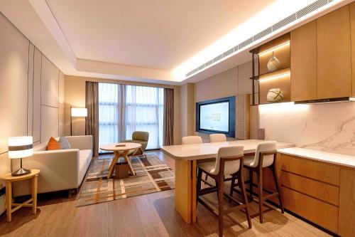 a kitchen and living room with a table and chairs at Courtyard by Marriott Nanning Wuxiang in Nanning