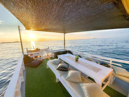 un bateau avec des tables et des chaises blanches sur l'eau dans l'établissement KLM Senayla, à Labuan Bajo