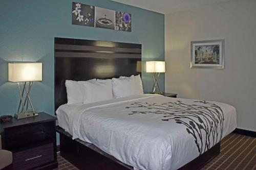 a large bed in a hotel room with two lamps at Sleep Inn & Suites West Knoxville in Knoxville