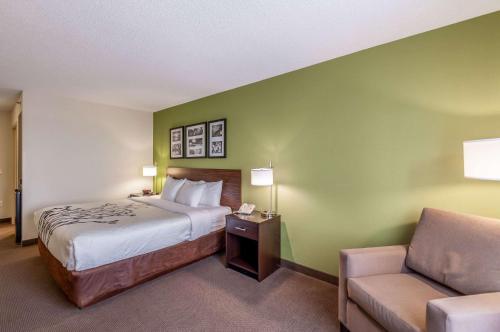 a hotel room with a bed and a chair at Sleep Inn & Suites Harrisonburg near University in Harrisonburg