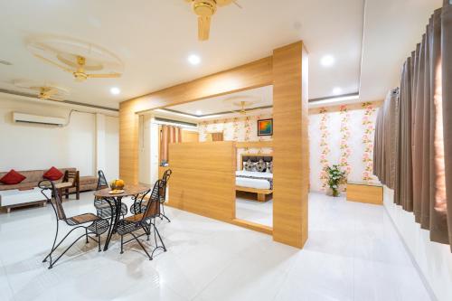 a dining room and living room with a table and chairs at Hotel Royal Palace in Sāgar