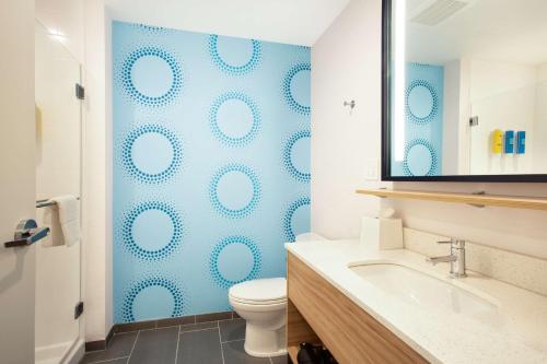 a bathroom with a toilet and a blue wall at Tru by Hilton Asheville Blue Ridge Parkway in Asheville
