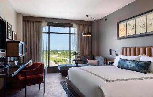 a hotel room with a bed and a large window at Thompson Savannah, by Hyatt in Savannah