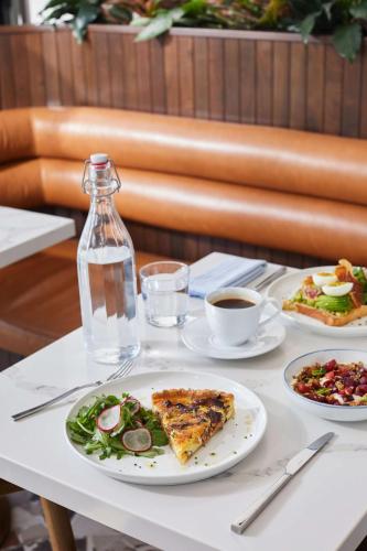 a table with plates of food and a bottle of water at Thompson Savannah, by Hyatt in Savannah
