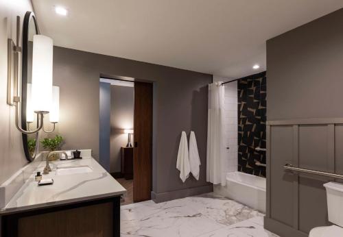 a bathroom with a sink and a tub and a shower at Thompson Savannah, by Hyatt in Savannah