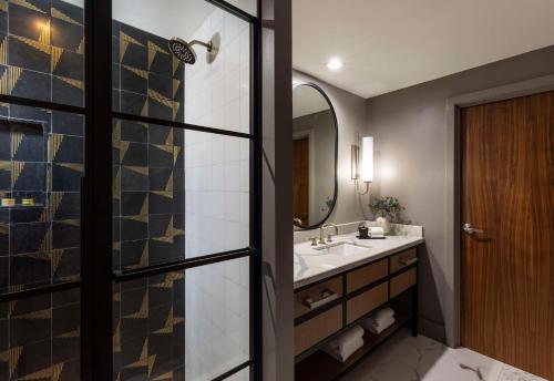 a bathroom with a sink and a mirror at Thompson Savannah, by Hyatt in Savannah