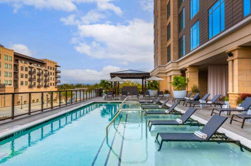 a swimming pool with lounge chairs on a building at Thompson Savannah, by Hyatt in Savannah