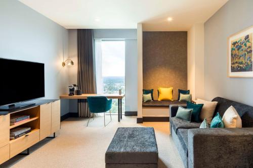 a living room with a couch and a tv at Hilton Woking in Woking