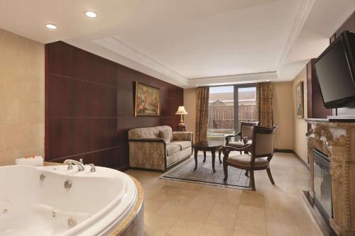 a large bathroom with a tub and a living room at Radisson Hotel Toronto Airport West in Mississauga