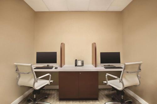 a office with two desks with two monitors and two chairs at Radisson Hotel Toronto Airport West in Mississauga