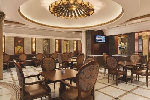a dining room with tables and chairs and a chandelier at Radisson Hotel Toronto Airport West in Mississauga