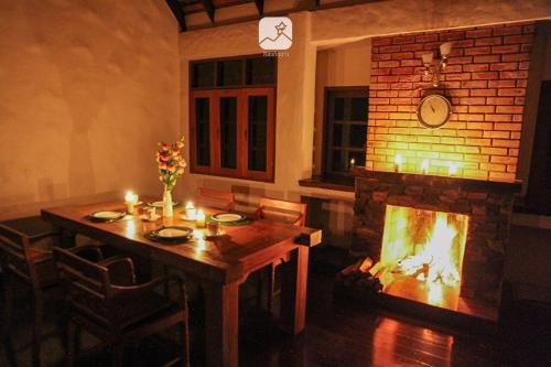 a dining room with a table and a fireplace at Baan Saket Dao, Ban Saket Dao, Doi Saket, Chiang Mai in Doi Saket