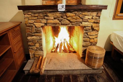 a stone fireplace with a fire in it at Baan Saket Dao, Ban Saket Dao, Doi Saket, Chiang Mai in Doi Saket